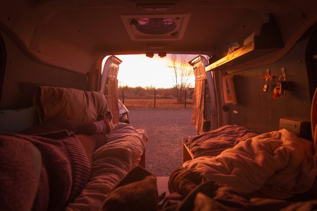 Van life is helping Sarah pay off her debt. Click here to learn more about living in a van and how she built her van dwelling. #vanlife #vandwelling #vanlifehacks #vanlifeDIY #vanlifeideas